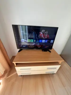 a flat screen tv sitting on top of a wooden stand at Sunny day 5 in Tŭnkovo