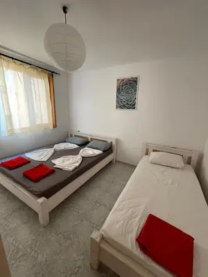 a bedroom with two beds and a pendant light at Bonne Chance Apartment Sozopol in Sozopol