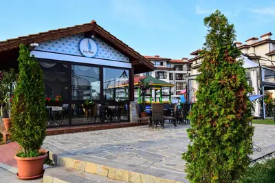 a patio with a restaurant with tables and chairs at Sea Club Sarafovo Apartments in Burgas City