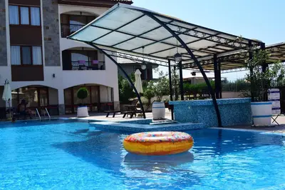 a swimming pool with a raft in the water at Sea Club Sarafovo Apartments in Burgas City