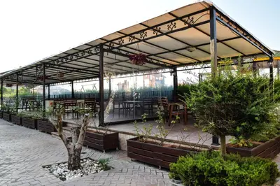 a greenhouse with tables and potted plants and trees at Sea Club Sarafovo Apartments in Burgas City