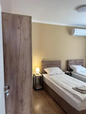 a bedroom with two beds and a sliding door at Апартаменти Bella Deluxe in Ravda