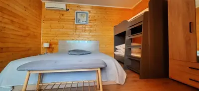 a bedroom with a bed with a bench in it at Бунгало Шангри Ла - 2, плаж Градина in Sozopol