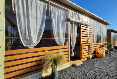 a house with white curtains and a potted plant at Бунгало Шангри Ла - 2, плаж Градина in Sozopol
