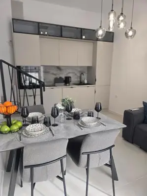a dining room table with two chairs and a kitchen at Grand Villa Deluxe Apart in Sveti Vlas