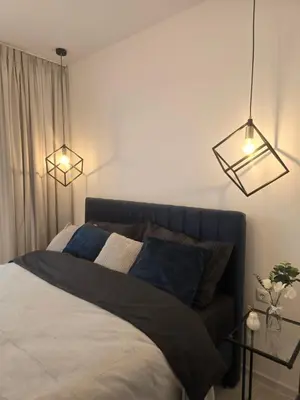 a bedroom with a bed with two lights above it at Grand Villa Deluxe Apart in Sveti Vlas