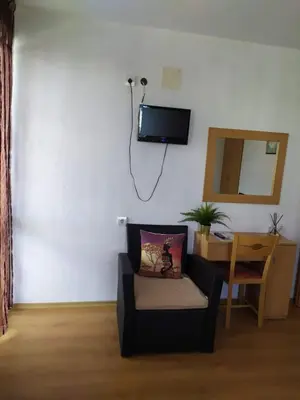 a living room with a chair and a tv on the wall at Guest house Pepina in Obzor