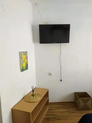 a room with a table and a television on a wall at Guest house Pepina in Obzor