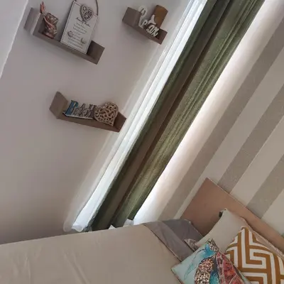 a bedroom with a bed and a window and shelves at Apartment Violeta - with sea view in 1st line Sarafowo in Burgas City