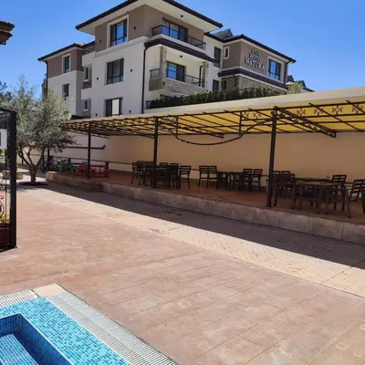 a patio with tables and chairs and a building at Apartment Violeta - with sea view in 1st line Sarafowo in Burgas City