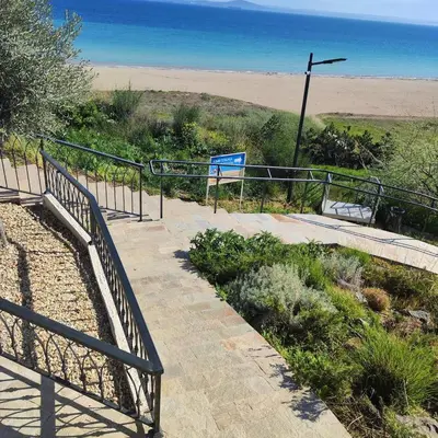 a stairway leading up to a beach with a fence at Apartment Violeta - with sea view in 1st line Sarafowo in Burgas City
