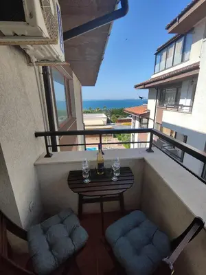a small balcony with a table and two chairs at Apartment Violeta - with sea view in 1st line Sarafowo in Burgas City