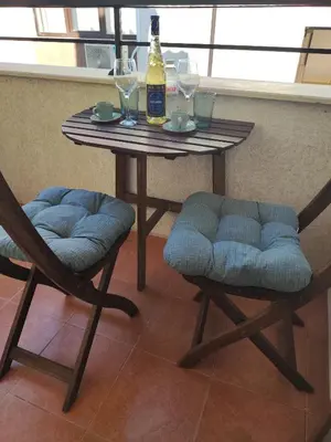 a table with two chairs and a bottle of beer at Apartment Violeta - with sea view in 1st line Sarafowo in Burgas City