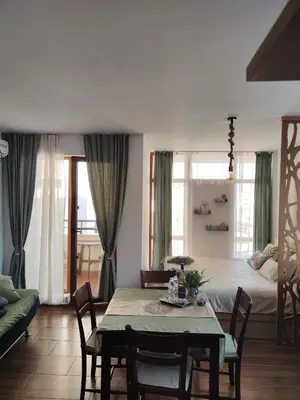 a living room with a table and a bed at Apartment Violeta - with sea view in 1st line Sarafowo in Burgas City