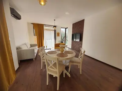 a living room with a table and chairs and a couch at Вила Винсент - Villa Vincent in Lozenets
