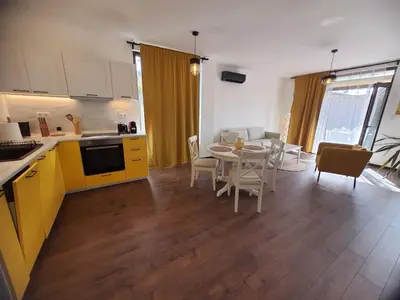 a kitchen and living room with a table and chairs at Вила Винсент - Villa Vincent in Lozenets