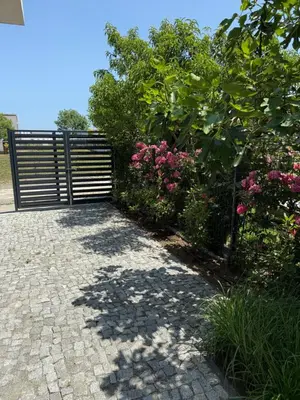a gate in a garden with pink flowers at Вила Винсент - Villa Vincent in Lozenets