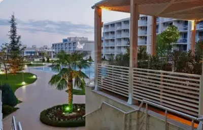 a resort with a palm tree and a building at The Red Studio in Burgas City