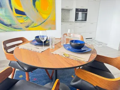 a dining room table with two bowls and wine glasses at Luxus Art Apartament Burgas in Burgas City