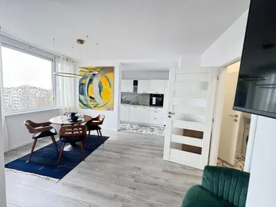 a kitchen and dining room with a table and chairs at Luxus Art Apartament Burgas in Burgas City