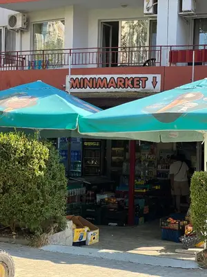 an outdoor market with a blue umbrella and books at Fort Noks PRIVILEGE Apartment in Sveti Vlas