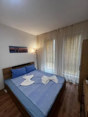 a bedroom with a blue bed with two white towels on it at Съни Дей ,Слънчев бряг in Burgas City
