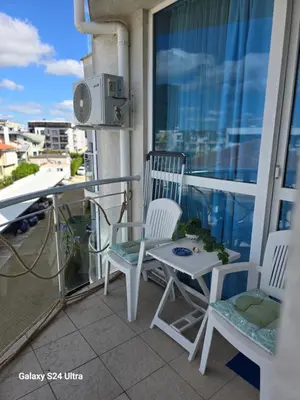 a balcony with two chairs and a table on a balcony at Apartament Primavera Atlantis SPA in Burgas City