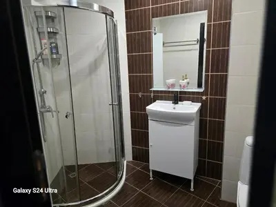 a bathroom with a shower and a sink and a mirror at Apartament Primavera Atlantis SPA in Burgas City