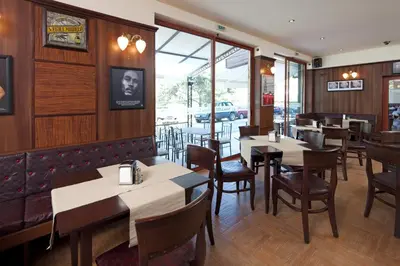 a restaurant with wooden walls and tables and chairs at Hotel Lira in Sunny Beach