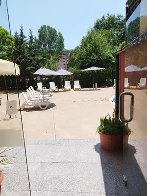 a patio with chairs and tables and umbrellas at Pacyfik3 in Sunny Beach