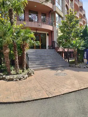 a building with stairs and palm trees in front of it at Pacyfik3 in Sunny Beach