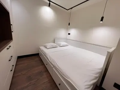 a small bedroom with a bed with white sheets at Maxim Apartment with Free Parking in Varna City
