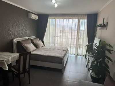 a bedroom with a bed and a table and a plant at Lovely Studio with Sea View Grand Hotel Sveti Vlas in Sveti Vlas