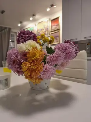 a white vase filled with colorful flowers on a table at Central park apartment Сентрал парк апартамент Бургас in Burgas City