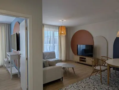 a living room with a couch and a tv at Solea Suites in Chernomorets