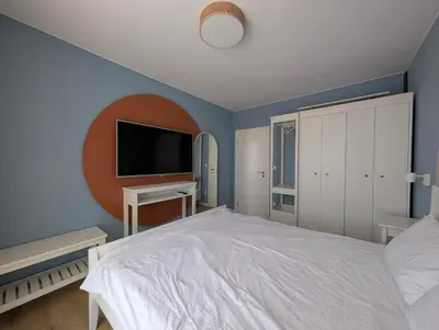 a bedroom with a bed and a flat screen tv at Solea Suites in Chernomorets