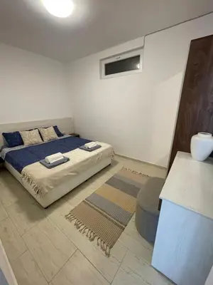 a bedroom with a bed with blue sheets and a window at Апартамент Студио Endless Созопол in Sozopol
