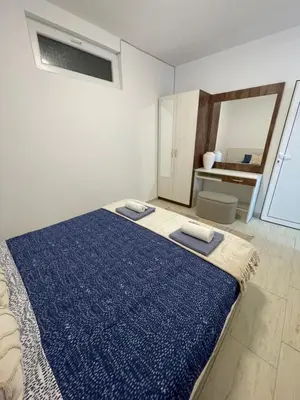 a bedroom with a bed with a blue blanket on it at Апартамент Студио Endless Созопол in Sozopol