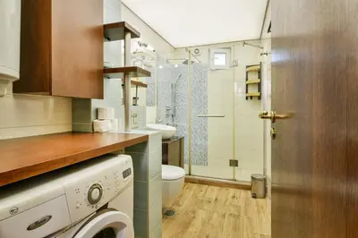a bathroom with a washer and a toilet and a sink at Budget Flat in Central Varna in Varna City