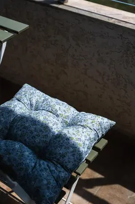 a pillow sitting on a chair next to a window at Luxury apartment with sea view,FREE parking! in Varna City