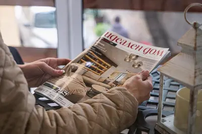 a person is reading a magazine at a table at Cozy Studio in Varna City Center in Varna City