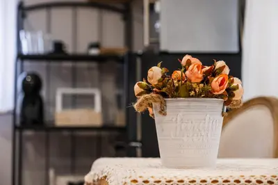 a bucket of flowers sitting on a table at Cozy Studio in Varna City Center in Varna City
