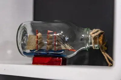 a miniature ship in a bottle on a shelf at Cozy Studio in Varna City Center in Varna City