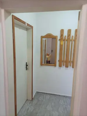 a hallway with a door and a mirror on a wall at Rita's - family apartment by the sea in Primorsko