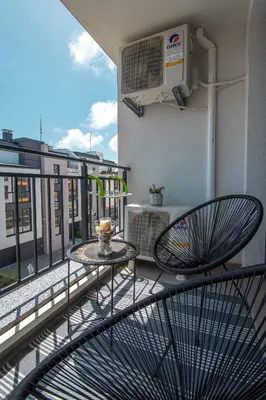 a balcony with a table and chairs on a balcony at Boho Apartment Sozopol in Sozopol