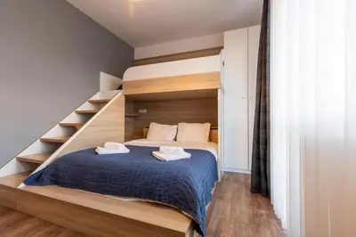 a small bedroom with a bed with a staircase at Spacious, free parking, 3min beach, Flora Panorama in Burgas City