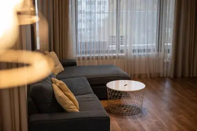 a living room with a couch and a table at Spacious, free parking, 3min beach, Flora Panorama in Burgas City