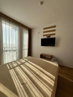 a bedroom with a large bed and a large window at Nemo's apartment - Sunny Beach in Sunny Beach