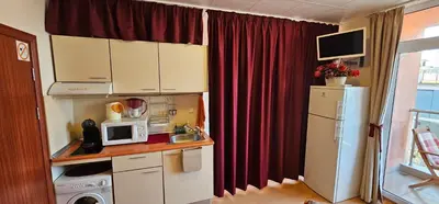 a small kitchen with a refrigerator and a microwave at Rainbow 2 studio 40 in Sunny Beach