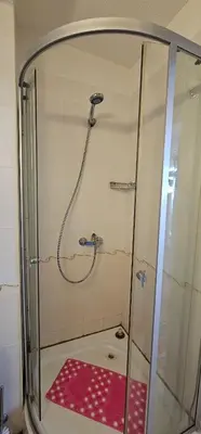 a shower with a glass door with a red shower mat at Rainbow 2 studio 40 in Sunny Beach